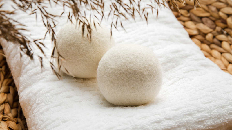 Two woll dryer balls on a white towel—Do wool dryer balls reduce drying time?