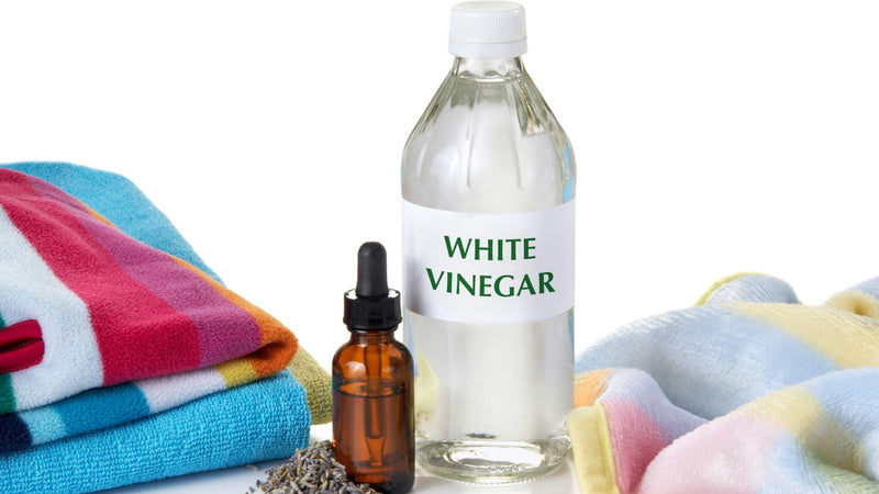 White vinegar, bottle of essential oils, and towels—How do you make your own laundry softener